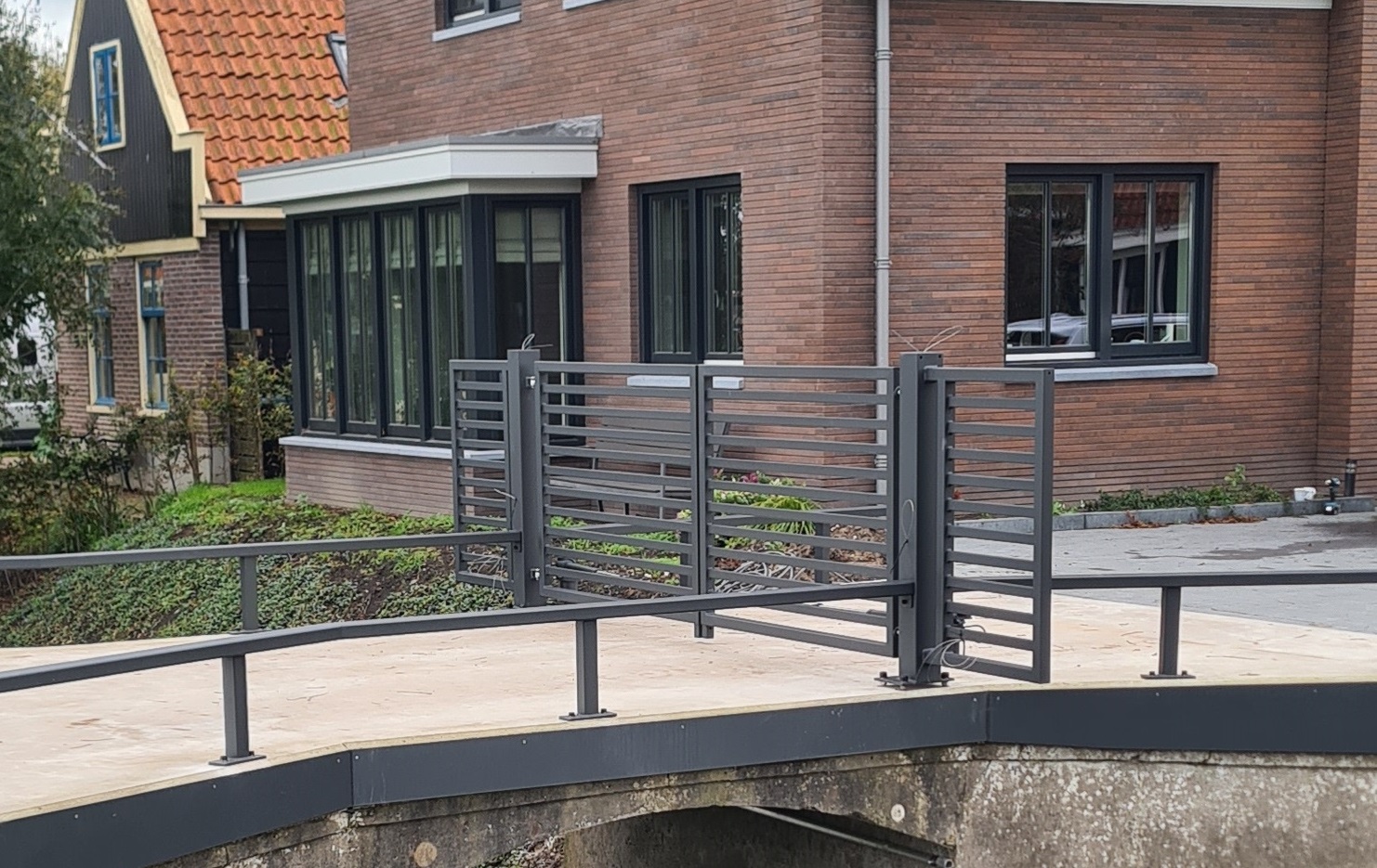 Moderne inrijpoort horizontale spijlen lamellenhek geautomatiseerd gemaakt door Boon Metaal de Goorn